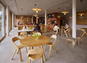 a restaurant with tables and chairs and people sitting at tables at Schaan-Vaduz Youth Hostel in Schaan