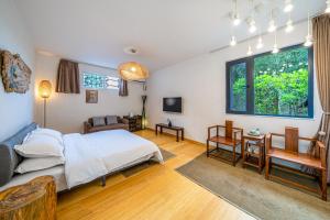 安吉県にある安吉 小森林 Little Forest Anjiのベッドルーム1室(ベッド1台付)、リビングルームが備わります。