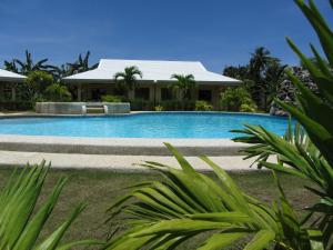 a swimming pool in front of a house at Bohol Sunside Resort in Panglao