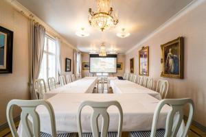Karolineburg Manor House Hotel في كاياني: قاعة اجتماعات كبيرة مع طاولة وكراسي طويلة