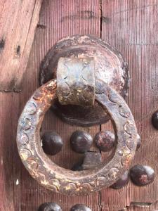Les Jardins de Ryad Bahia في مكناس: مزلاج معدني قديم على باب خشبي