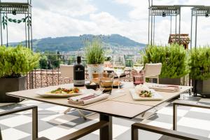 una mesa con platos de comida y vino en el balcón en Hotel Bellevue Palace Bern, en Berna