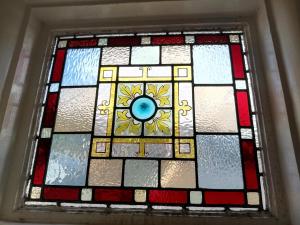 a stained glass window with a flower on it at Durham House in Beer