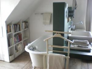 a bathroom with a bath tub and a sink at Holiday Home Stilleven in Veurne