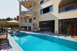 a house with a swimming pool next to a building at Villa Andreas in Panormos Rethymno +43 photos