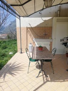 eine Terrasse mit einem Tisch, Stühlen und einem Grill in der Unterkunft Casa di Heidi in Cerreto Sannita