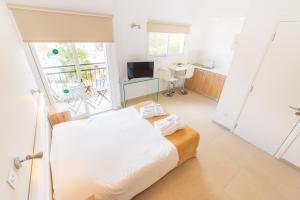 a bedroom with a bed and a desk and a window at Chrielka Hotel in Limassol