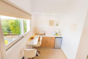a white kitchen with a sink and a window at Chrielka Hotel in Limassol