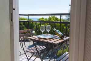 a table with glasses and wine bottles on a balcony at Chrielka Hotel in Limassol