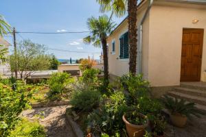 a house with a lot of plants in front of it at JELICIC C in Crikvenica