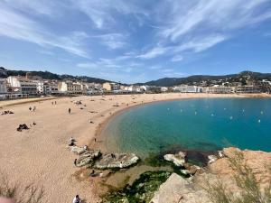 Una playa con mucha gente en el agua en VIDABRAVA, Tossa Medievo, apartamento a 150 m de la playa, en Tossa de Mar