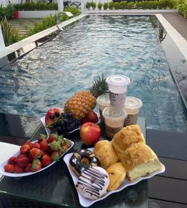 a tray of food on a table next to a swimming pool at Villa nguyên căn 4 phòng ngủ, cạnh biển Thuận An Rabbit Home Villa in Phú Vang +11 photos
