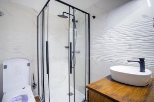 a bathroom with a sink and a glass shower at Résidence Nokoshima in Fort-de-France