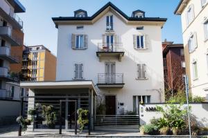 a white building with a balcony on the front at AMA 18 Rooms - The House Of Travelers- in Como