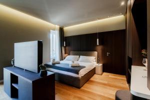 a bedroom with a bed and a tv in it at AMA 18 Rooms - The House Of Travelers- in Como