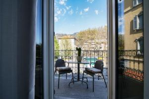 un patio con tavolo e sedie sul balcone. di AMA 18 Rooms - The House Of Travelers- a Como