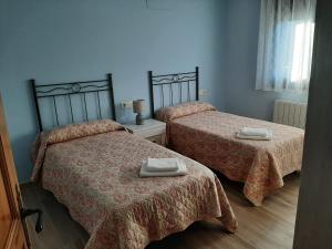 a bedroom with two beds with towels on them at Alojamientos Rurales Hurdes Altas - La Antigua Guarderia in Casares de las Hurdes +134 photos