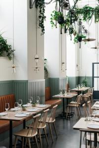 a row of tables and chairs in a room with plants at The Lisboans Apartments in Lisbon +57 photos