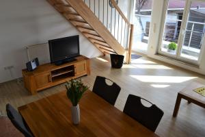 sala de estar con TV, mesa y sillas en An der Kapf, en Münsingen