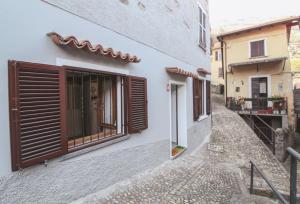 a house with wooden shutters on a street at Al Beniss in Acquaseria