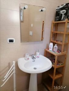 a bathroom with a white sink and a mirror at Alloggi Estivi D & A in Taranto