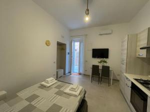 a bedroom with a bed and a kitchen with a table at AP Apartment - in centro! in Gallipoli