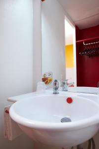 lavabo blanco en el baño con espejo en Première Classe Toulouse Nord - L'Union en LʼUnion