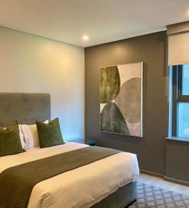 a bedroom with a bed and a painting on the wall at Umhlanga Arch Gem in Durban