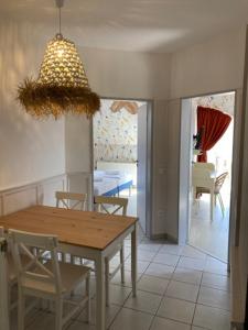 a dining room with a table and chairs and a light fixture at Levendula Apartman in Balatonfüred