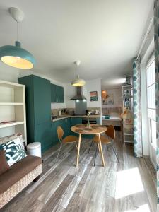 a living room with a table and a kitchen at STUDIO, UN HAVRE DE PAIX - BIDART ERRETEGIA in Bidart