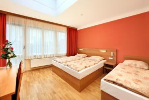 a hotel room with two beds and two windows at Residence BENE in Prague
