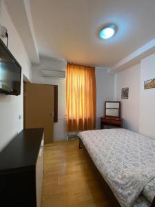 a bedroom with a bed and a flat screen tv at Budget Inn Amzei in Bucharest