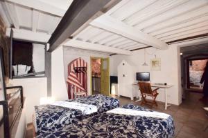 een kamer met 2 bedden, een bureau en een tafel bij IL NIDO in Campiglia Marittima