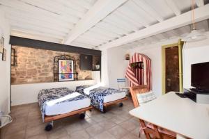 a bedroom with two beds and a table and a desk at IL NIDO in Campiglia Marittima