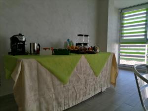 a table with a green table cloth with fruit on it at B&B Casa Dany in Ricadi