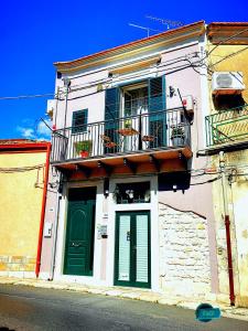 un edificio con porta verde e balcone di Casa Vacanze Le Giuseppine a Modica