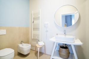 bagno con lavandino, servizi igienici e specchio di Enjoy Your Stay - Guest House - Olbia a Olbia