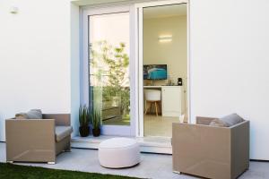 een woonkamer met 2 stoelen en een glazen schuifdeur bij Enjoy Your Stay - Guest House - Olbia in Olbia