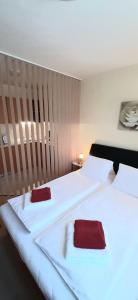 um quarto com 2 camas com toalhas vermelhas em ÉKKŐ APARTMAN em Hegykő