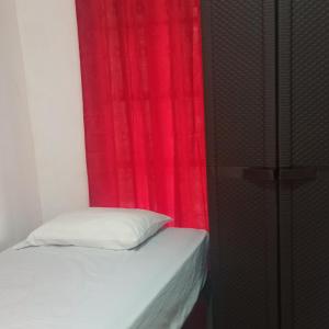 1 dormitorio con cortina roja y cama en La Casa de Thurys, en Pedasí Town