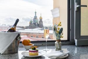 a table with a glass of wine and a bottle of champagne at 3 MostA in Saint Petersburg