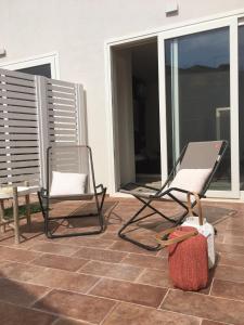 twee stoelen op een patio met een tafel en een stoel bij La Bottarga in Favignana