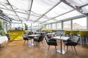 a restaurant with tables and chairs and windows at 3 MostA in Saint Petersburg