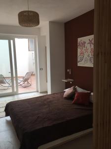 - une chambre avec un grand lit et un balcon dans l'établissement La Bottarga, à Favignana