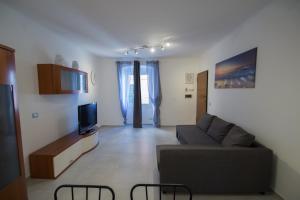 a living room with a couch and a tv at Appartamento piazza Buccelli a 10 mt dal mare in Varazze