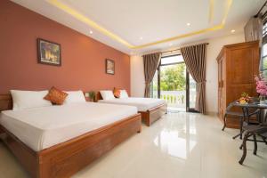 a hotel room with two beds and a table at Spring Garden Villa Hoi An in Hoi An +34 photos
