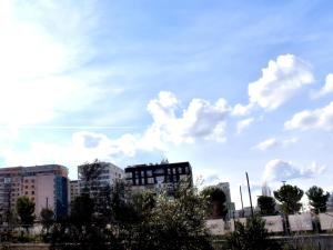 a city skyline with buildings and a cloudy sky at Hotel Central in Tirana