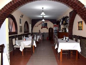 a dining room with white tables and chairs and an archway at Hotel Central in Tirana