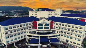 een groot wit gebouw met een blauw dak bij Hotel Villa in Seremban