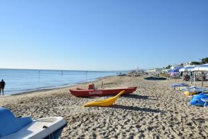 a beach with a boat and a yellow slide at Hotel Petite Fleur in Alba Adriatica